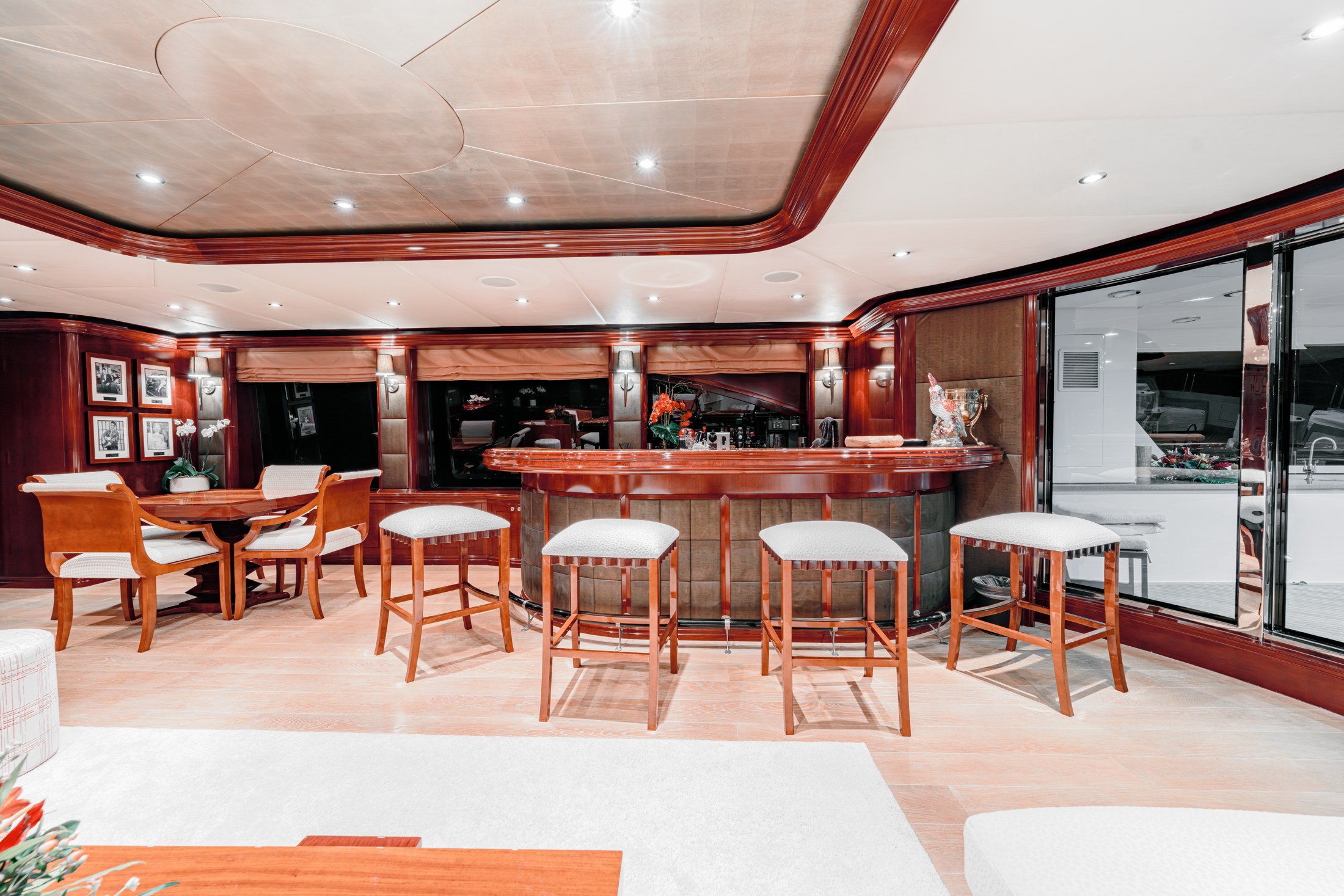 The main salon with warm timber cabinetry and white seating